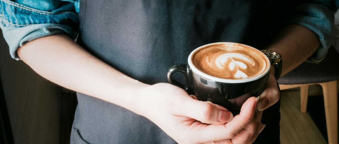 woman holding mug of cappuccino