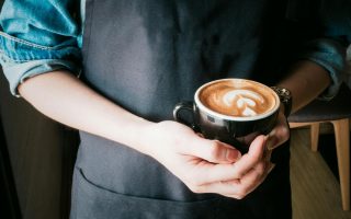 woman holding mug of cappuccino